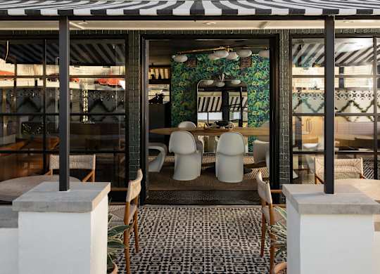 A restaurant with a black and white striped awning and a mosaic tile floor at The PARKER on E Mulberry Apartments, San Antonio, TX, 78209