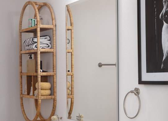 A bathroom with a white vanity and a round mirror at The PARKER on E Mulberry Apartments, Texas