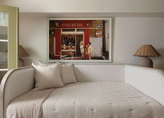 A bedroom with a bed and a picture of a bakery on the wall at The PARKER on E Mulberry Apartments, San Antonio, 78209