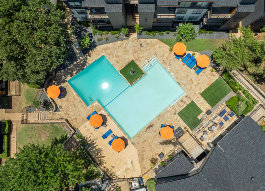 arial view of a pool and tennis court with orange umbrellas and trees at District 2308, Texas, 76011
