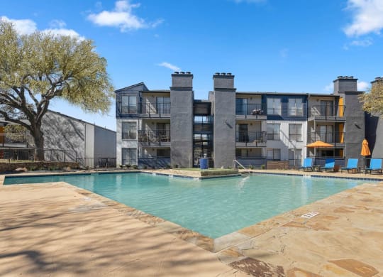 a swimming pool with a building in the background at District 2308, Texas, 76011