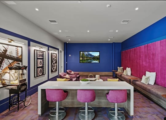 a living room with blue walls and a white table and chairs at Altis Grand Kendall, Florida, 33186