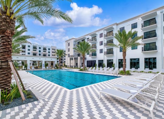 a swimming pool in front of a white apartment building with a pool at Altis Grand Kendall, Miami Florida