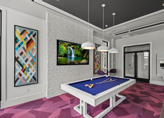 a game room with a blue pool table and a waterfall at Altis Grand Kendall, Florida