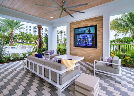 a patio with couches and a table and a television at Altis Grand Kendall, Miami, 33186