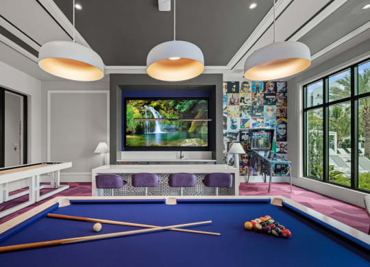 a billiards room with a blue pool table and a large window at Altis Grand Kendall, Miami Florida