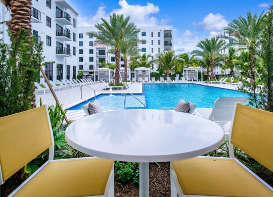 a swimming pool at a resort with a table and chairs at Altis Grand Kendall, Florida, 33186