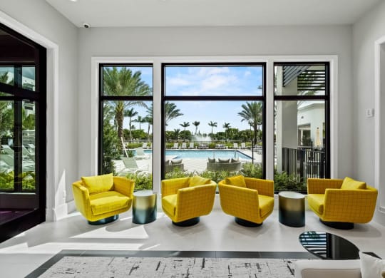 a living room with yellow chairs and a view of a swimming pool at Altis Grand Kendall, Miami, 33186