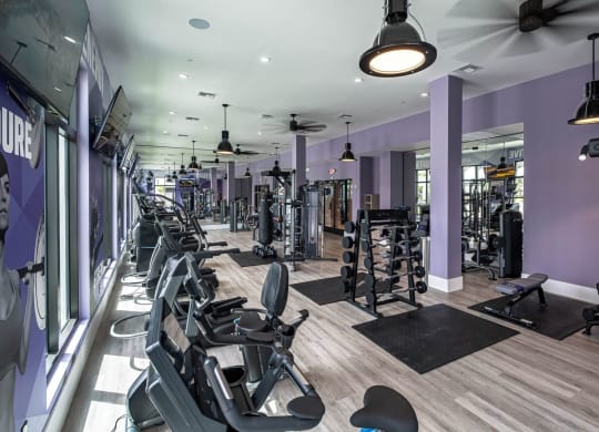 a gym with various machines and chairs in it at Altis Grand Kendall, Florida