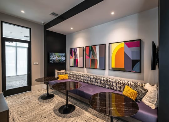 a living room with paintings on the wall and a purple couch at Altis Grand Kendall, Miami