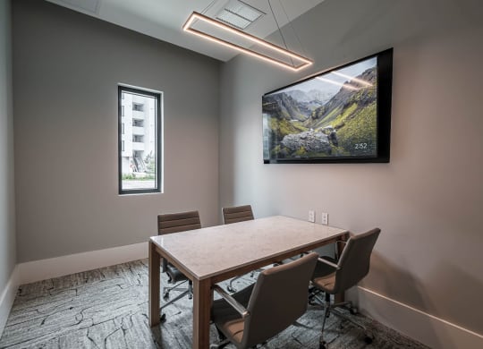 a conference room with a tv and a table with chairs at Altis Grand Kendall, Florida 
