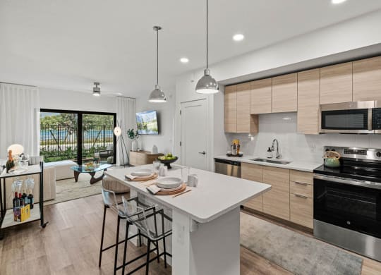 a kitchen with a large island and a stove and a sink at Altis Grand Kendall, Florida, 33186