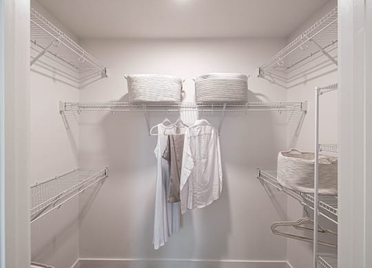 a walk in closet with wire shelves and clothes at Altis Grand Kendall, Florida
