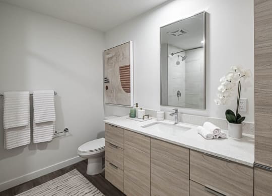 a bathroom with a sink and a toilet and a mirror at Altis Grand Kendall, Miami, FL
