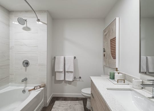 a bathroom with a tub and a sink and a mirror at Altis Grand Kendall, Miami Florida