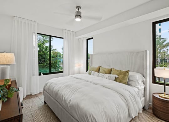 a bedroom with a large bed and two windows at Altis Grand Kendall, Miami, 33186