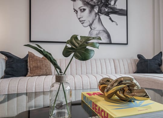 a living room with a couch and a table with a vase with a plant at Altis Grand Kendall, Miami, FL 33186