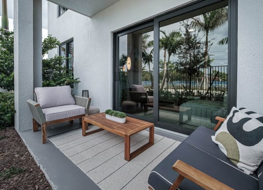 a patio with chairs and a table on a balcony at Altis Grand Kendall, Miami, FL 33186