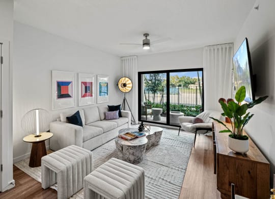 a living room with white furniture and a large window at Altis Grand Kendall, Miami
