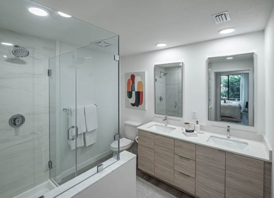 a bathroom with a shower and a sink and a mirror at Altis Grand Kendall, Florida, 33186