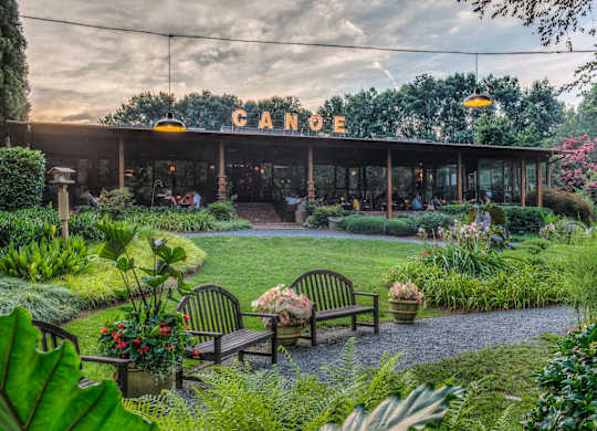 A Canopy restaurant with a garden in front.
