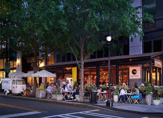 A restaurant with people dining outside at night.
