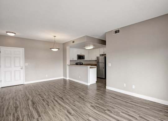 A kitchen area with a refrigerator, microwave, and oven.