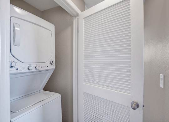 A white washing machine and dryer in a small laundry room.