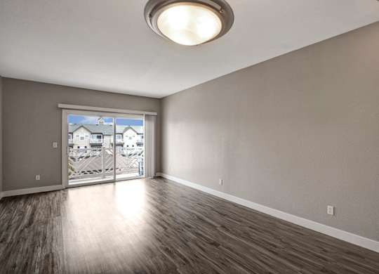 A room with a sliding glass door leading to a balcony.