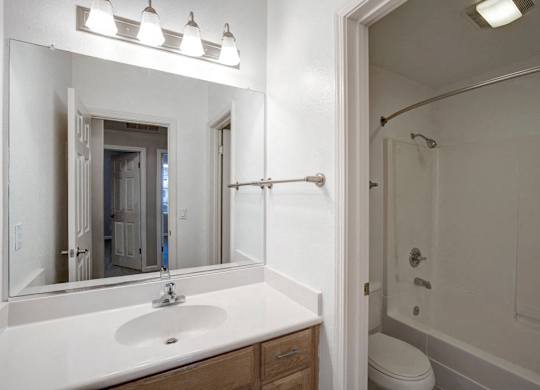 A bathroom with a white sink and a white toilet.