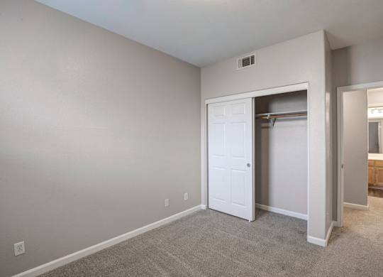 A room with a white door and carpeted floor.