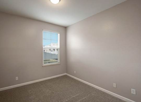 A room with a window and a car parked outside.