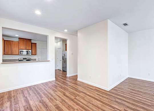 A room with wooden flooring and white walls.