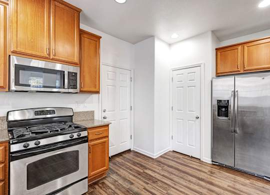 A kitchen with wooden cabinets and a stainless steel refrigerator.