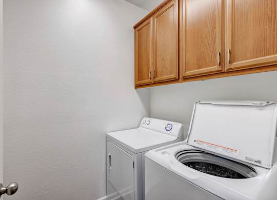 A white washing machine is in a small laundry room.