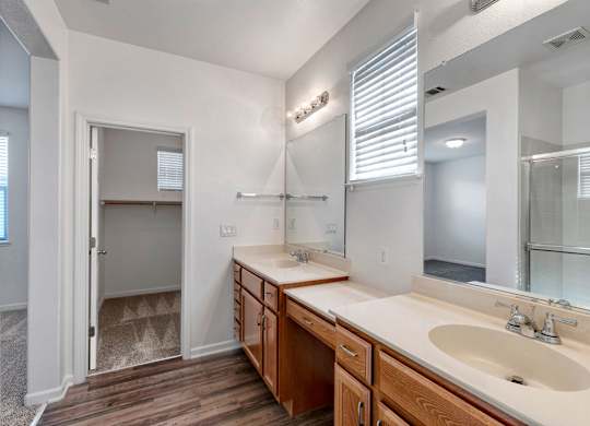 A bathroom with a sink, mirror, and a shower with a glass door.