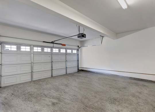 A spacious garage with a white ceiling and a grey floor.