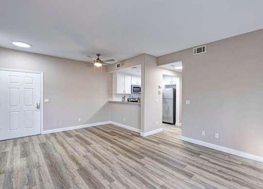 A room with a white door and a wooden floor.