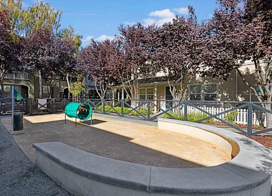 A playground with a slide and a green slide cover.