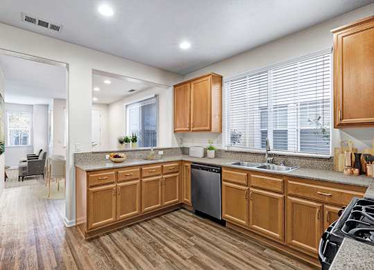 A kitchen with wooden cabinets and a black dishwasher.