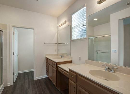 A bathroom with a sink, mirror, and wooden floors.