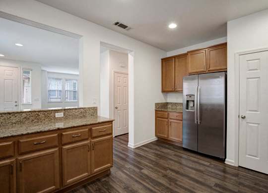 A kitchen with wooden cabinets and a granite countertop.
