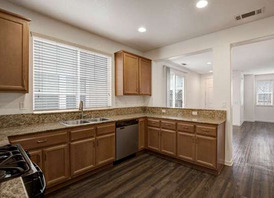 A kitchen with wooden cabinets and a granite countertop.