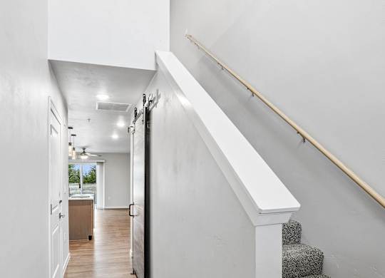 A hallway with a staircase and a skylight.