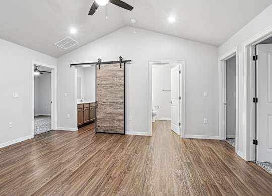 A room with a sliding door and hardwood floors.