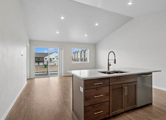 A kitchen with a sink, stove, and cabinets.