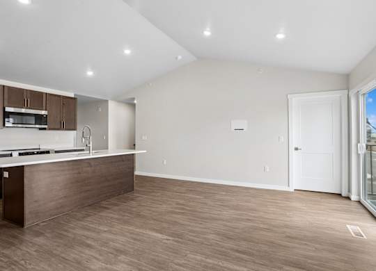 A kitchen with a white countertop and wooden flooring.
