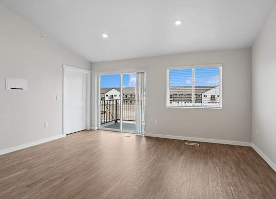 A room with a sliding glass door leading to a balcony.