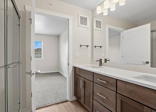 A bathroom with a white sink and brown cabinets.