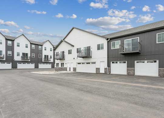 A row of modern townhouses with garages in front.